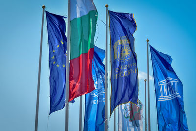 Low angle view of flags against blue sky