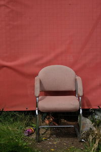Empty chairs against red wall