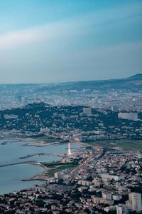 High angle view of townscape by sea against sky