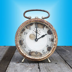 Close-up of clock on table against wall