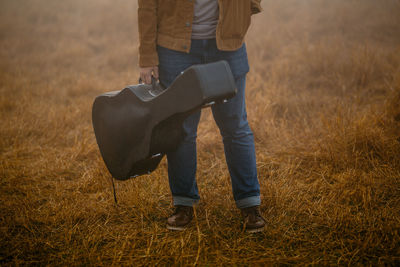 Low section of man standing on field