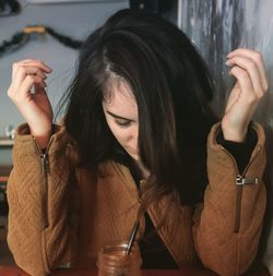 Close-up of young woman with drink sitting at table in cafe
