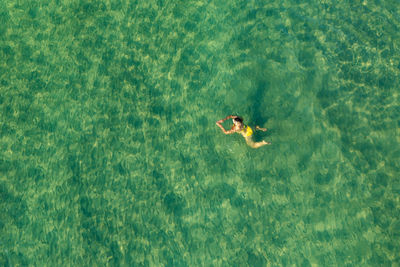 Aerial view of a girl swimming in the sea of koh rong island, cambodia