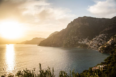 Scenic view of sea and mountains against sky