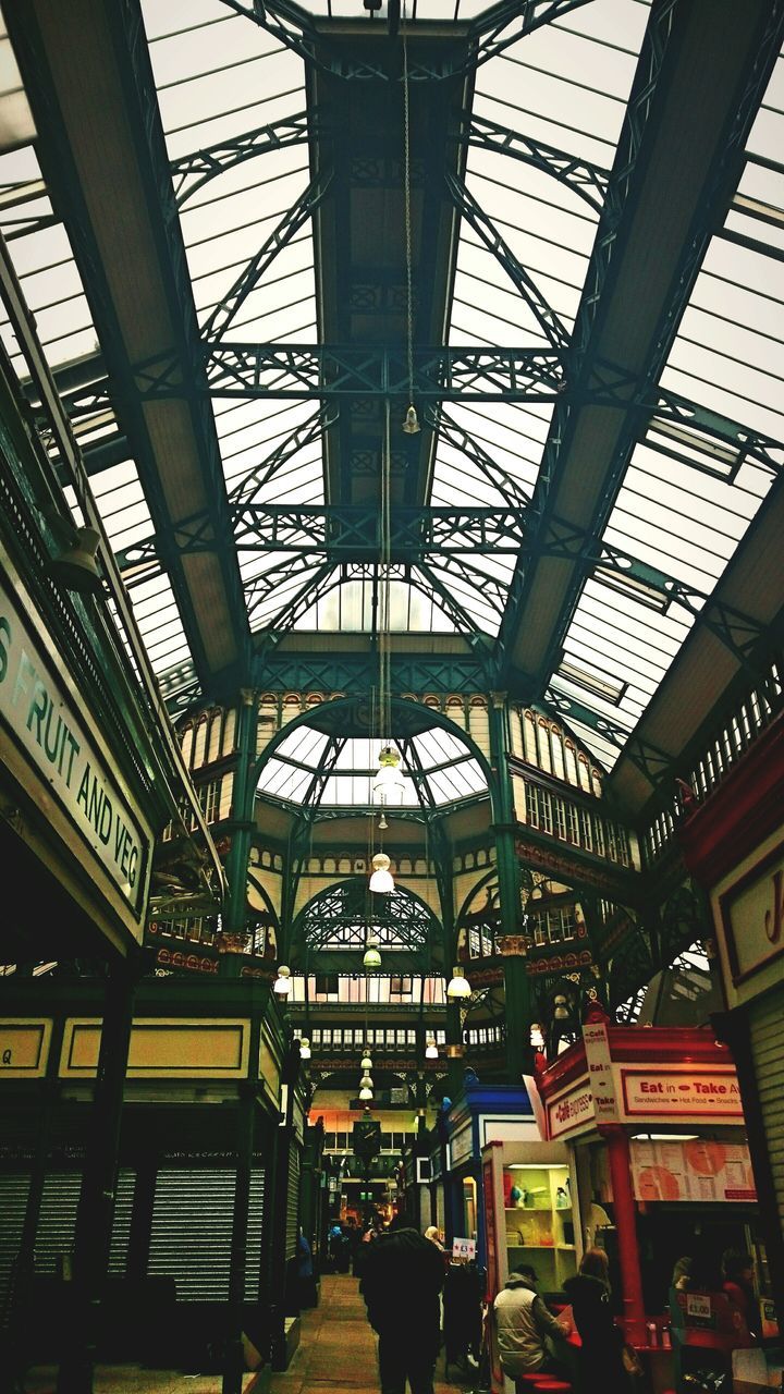 indoors, architecture, built structure, ceiling, low angle view, interior, railroad station, modern, incidental people, illuminated, window, architectural column, glass - material, travel, shopping mall, transportation building - type of building, transportation, lighting equipment, day, travel destinations