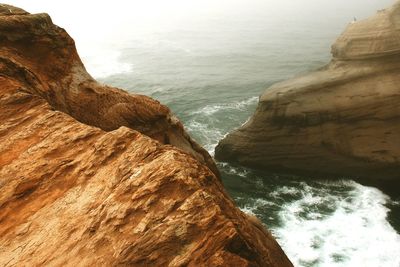 Scenic view of sea and rock formations during foggy weather