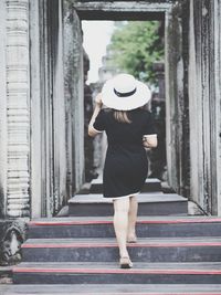 Rear view of young woman standing in city