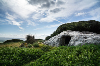 View of rocks on landscape against sky