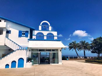 View of swimming pool by building against blue sky