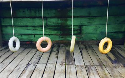 Close-up of tubes hanging wooden floor against wall