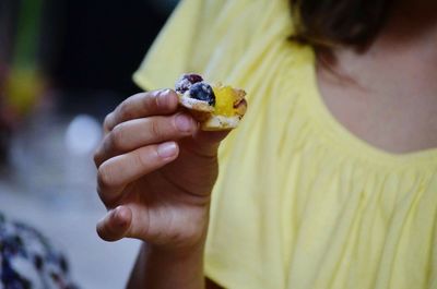 Midsection of woman holding cupcake