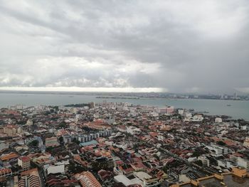 High angle view of townscape by sea against sky