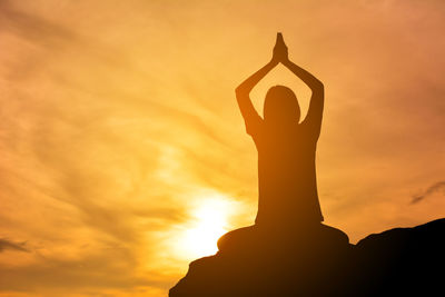 Low angle view of woman against sky during sunset