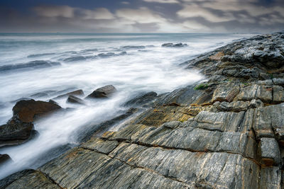 Waves and rocks under dramatic clouds