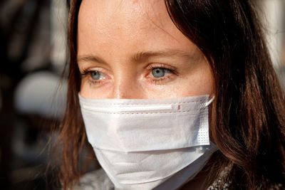 Close-up of woman wearing scarf and knit hat outdoors during winter