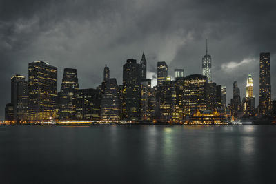 Scenic view of river against illuminated cityscape