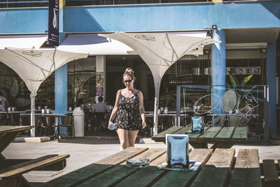 Portrait of young woman standing on table