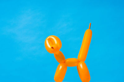 Low angle view of balloons against blue background