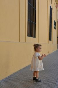 Girl standing against building