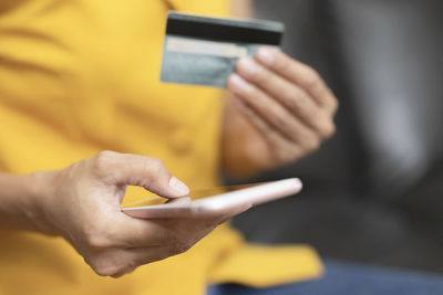 Midsection of man using mobile phone
