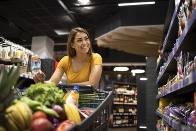 Portrait of young woman standing in supermarket