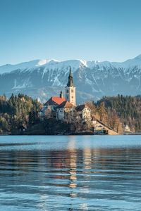 Scenic view of buildings by mountains against sky