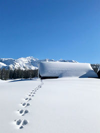 Snow covered mountain against clear blue sky