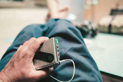 Midsection of man listening music at home