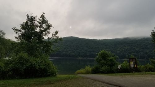 Scenic view of lake by trees against sky