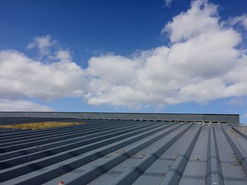 Metallic roof against cloudy sky