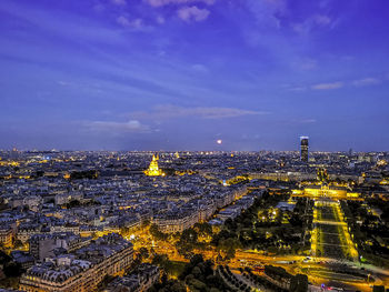 Aerial view of illuminated buildings in city at dusk