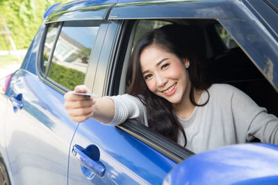Portrait of a smiling young woman sitting in car