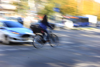 Blurred motion of people riding motorcycle on road in city