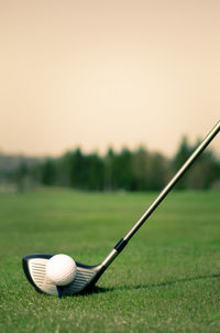 Ball on golf course against clear sky