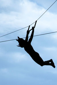 Low angle view of person paragliding against sky