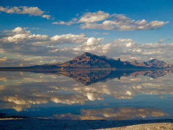 Scenic view of sea and mountains against sky