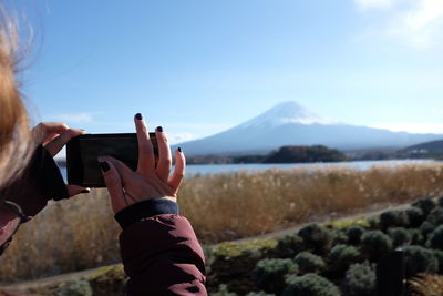Cropped image of woman photographing river