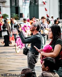 People photographing on street in city