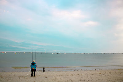 Rear view of man standing on shore at beach