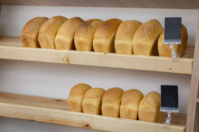 Bricks of wheat bread lie on wooden shelves in store. fresh delicious of bread loaves in bakery, 