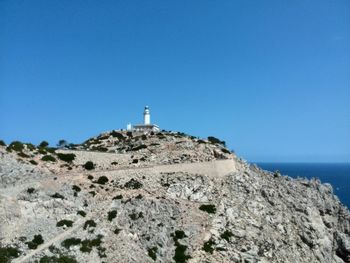 Low angle view of lighthouse against clear blue sky