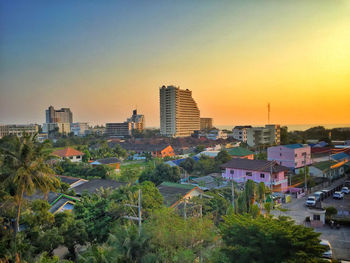 High angle view of trees and buildings against sky at sunset