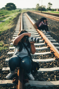 Man sitting on railroad track
