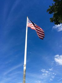 Low angle view of flag against blue sky