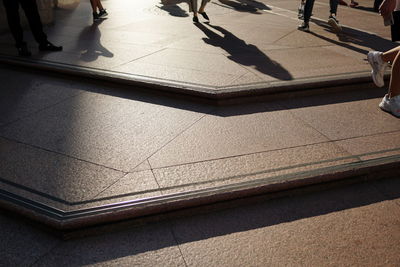 Low section of people walking on tiled floor