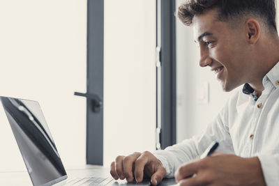 Young man using laptop at office