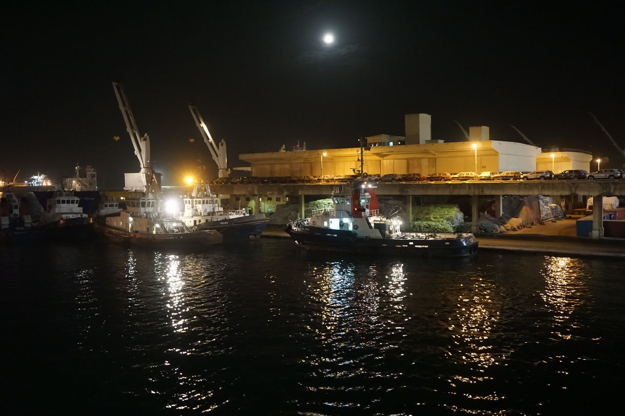 VIEW OF ILLUMINATED BUILDINGS AT WATERFRONT