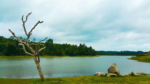 Scenic view of lake against cloudy sky