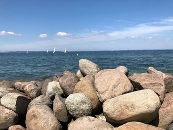 Rocks by sea against sky