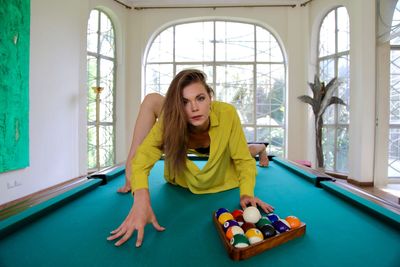 Sexy woman playing with pool ball on pool table